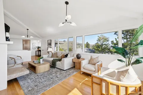 a living room with patio furniture and a large window