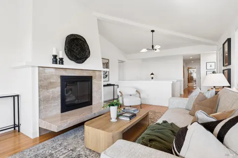 a living room with furniture a fireplace and wooden floor