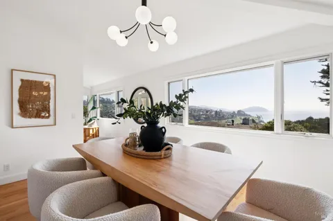a dining room with furniture and a large window