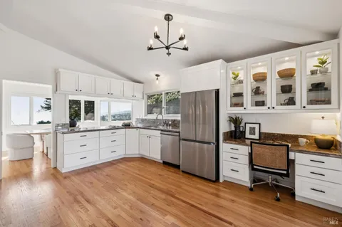 a kitchen with stainless steel appliances a stove refrigerator and cabinets