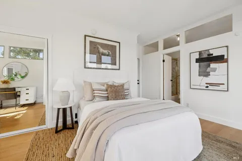 a bedroom with a bed and a lamp on dresser