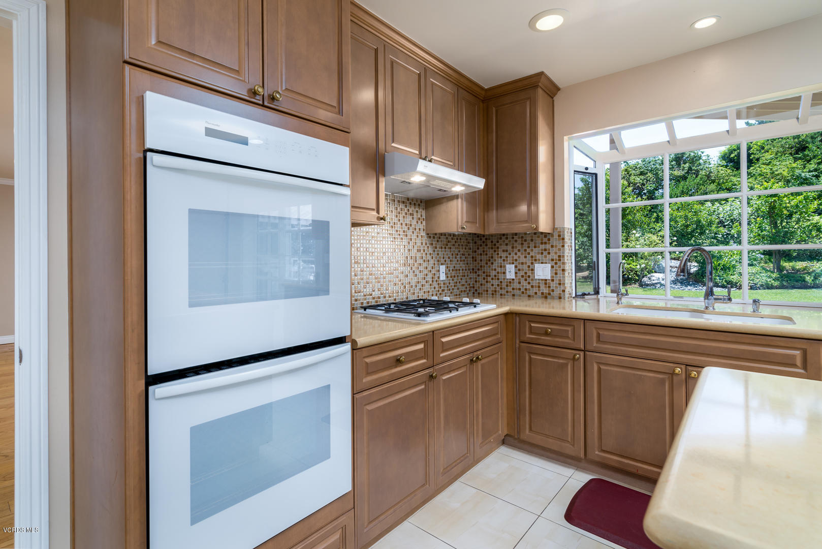 18932 Olympia Street Porter Ranch, CA 91326 - Photo 15 of 39 a kitchen with cabinets appliances and a window