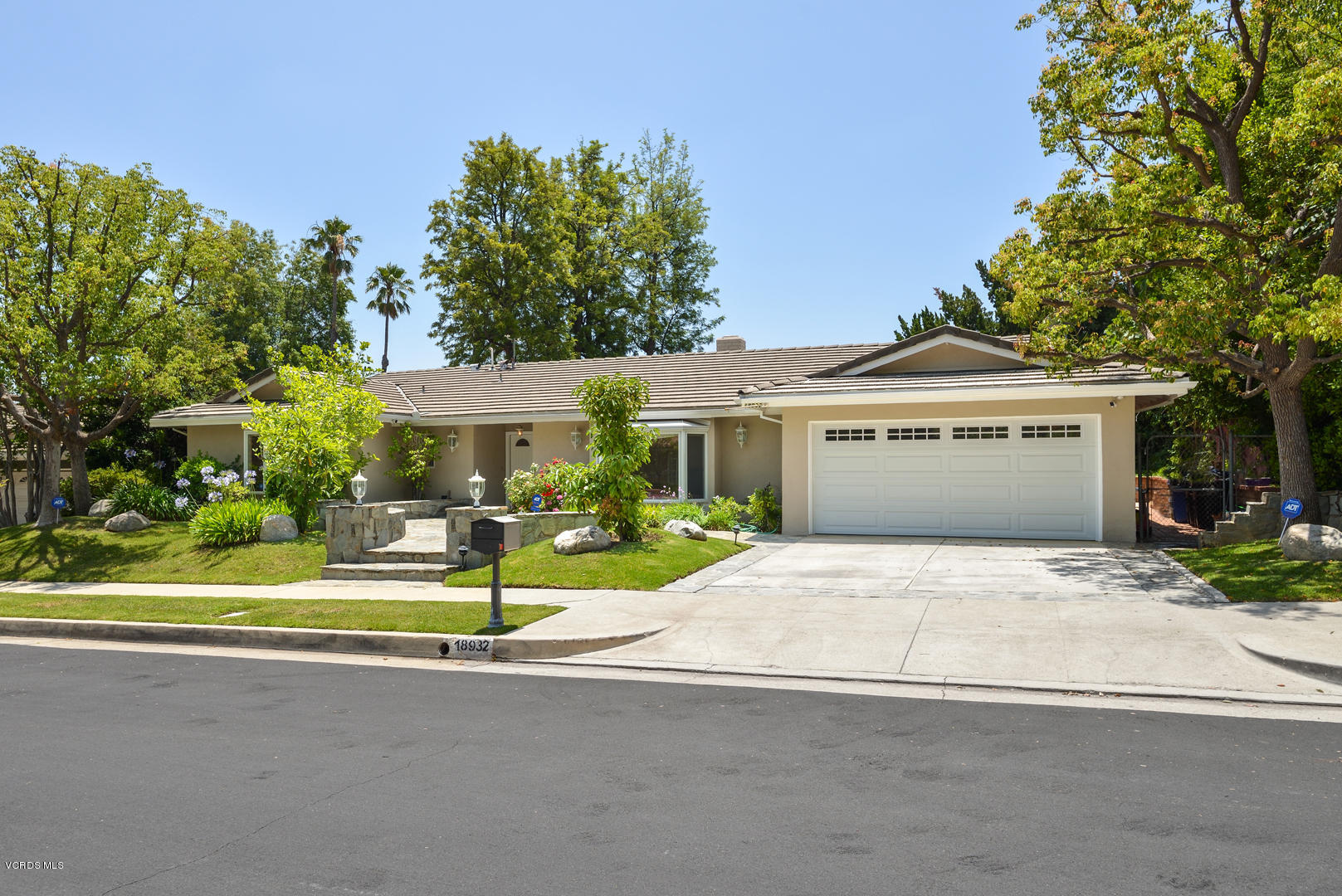18932 Olympia Street Porter Ranch, CA 91326 - Photo 3 of 39 a front view of a house with a garden and plants