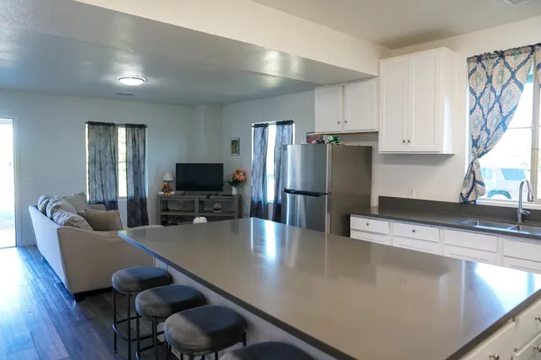 a kitchen with stainless steel appliances a dining table chairs and refrigerator