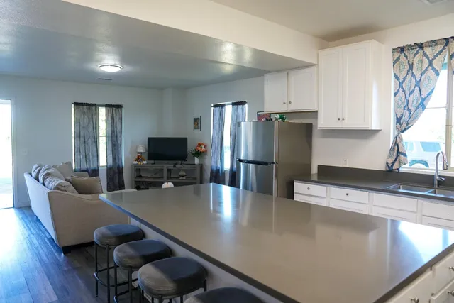 a kitchen with stainless steel appliances a dining table chairs and refrigerator