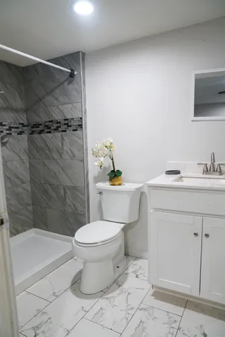 a bathroom with a sink a toilet and shower