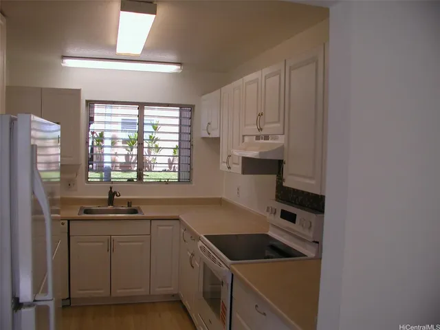 a kitchen with a sink and a stove top oven