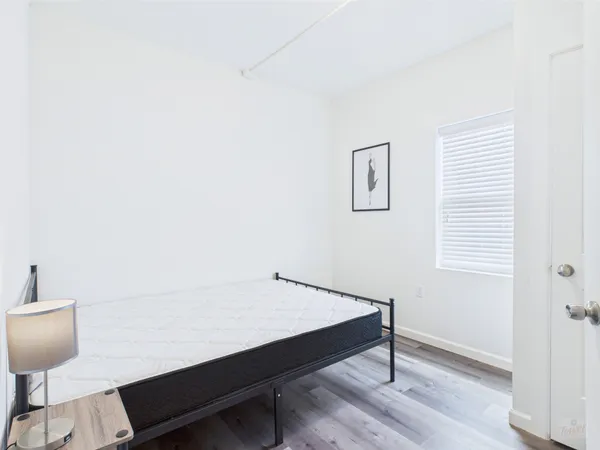 a bedroom with a bed and wooden floor