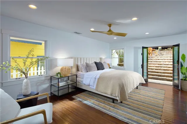 a spacious bedroom with a bed and wooden floor