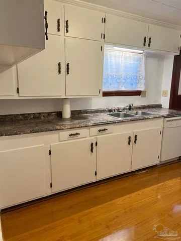 a kitchen with granite countertop white cabinets and white appliances