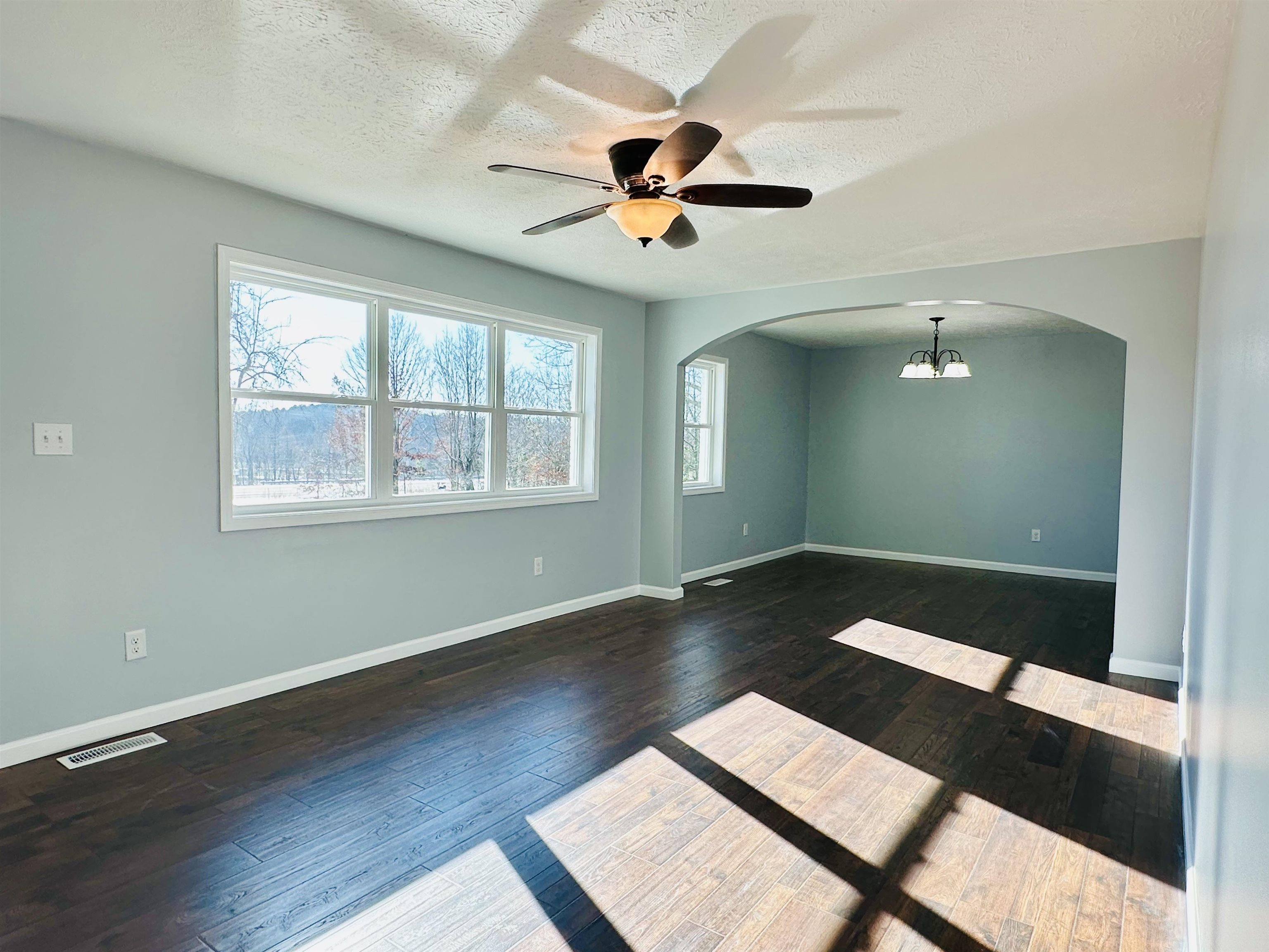 2317 Higginbottom Road Selmer, TN 38375 - Photo 3 of 20 Empty room with arched walkways, visible vents, dark wood finished floors, and baseboards