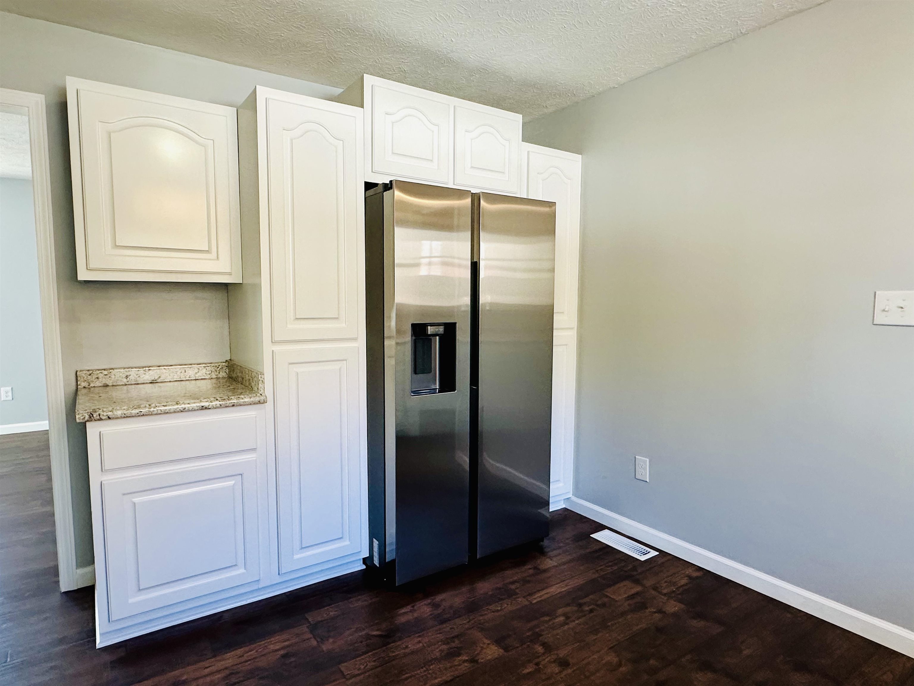 2317 Higginbottom Road Selmer, TN 38375 - Photo 9 of 20 Kitchen with baseboards, white cabinets, and stainless steel fridge with ice dispenser