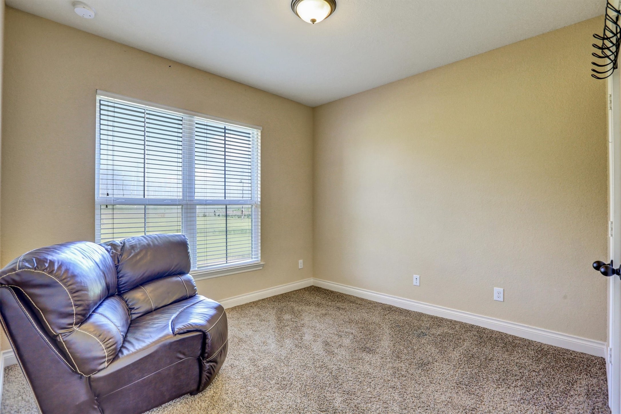 8131 Brinkmeyer Road Needville, TX 77461 - Photo 28 of 49 Cozy room with plush carpet and ample natural light from a large window, perfect for relaxation or a home office.