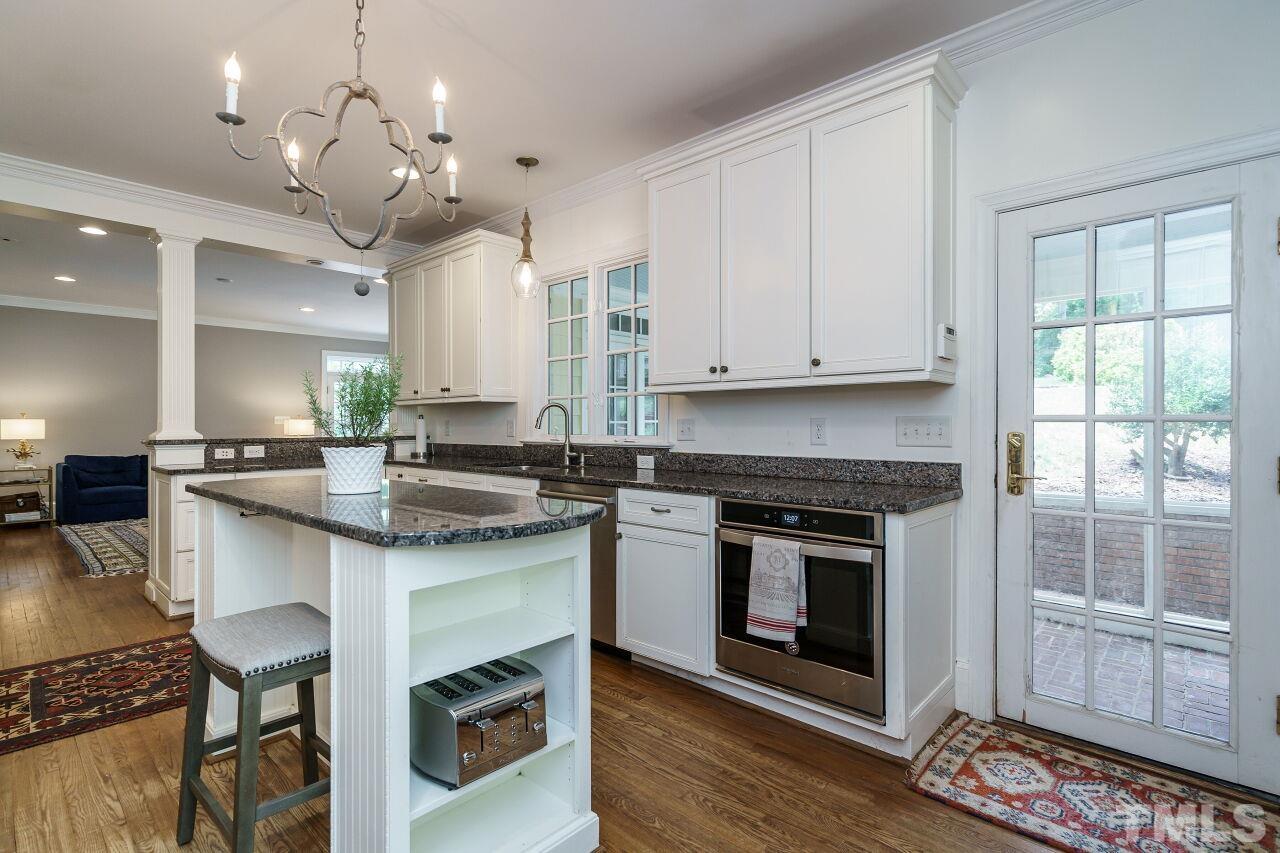 3201 Landor Road Raleigh, NC 27609 - Photo 14 of 41 a kitchen with kitchen island granite countertop a stove a sink and a refrigerator