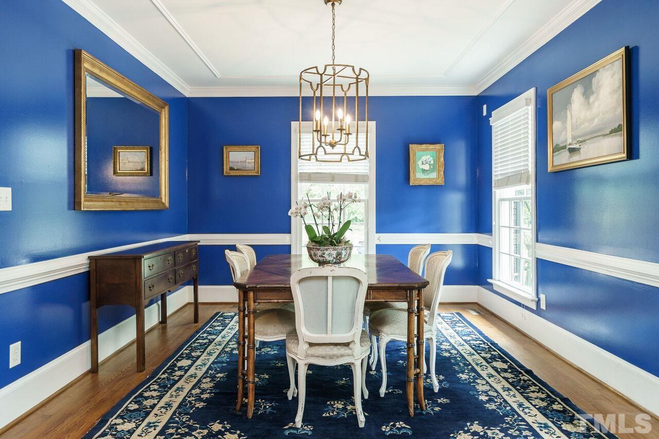 3201 Landor Road Raleigh, NC 27609 - Photo 9 of 41 a view of a dining room with furniture a chandelier and wooden floor