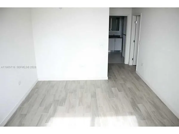 a view of an empty room and kitchen