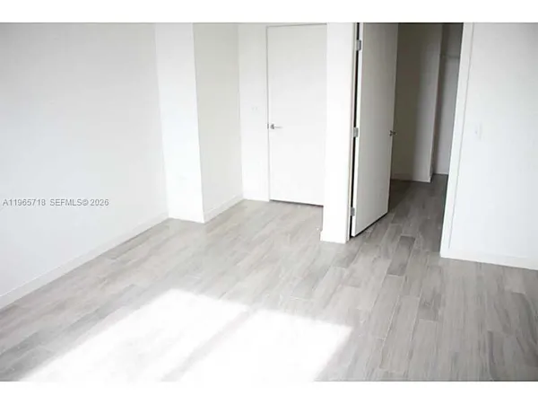 a view of a room with wooden floor