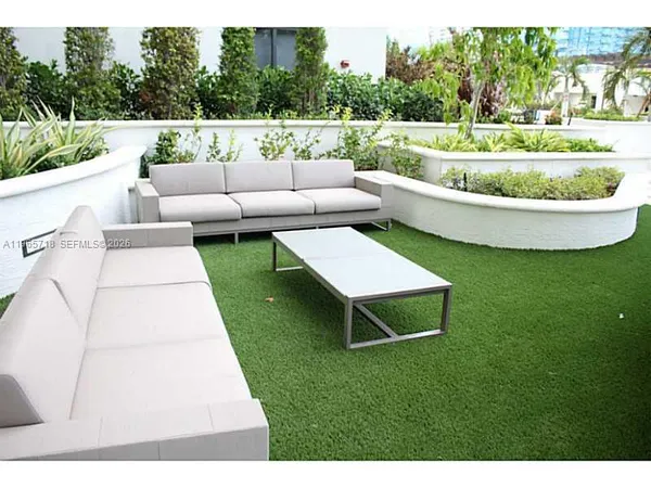 a view of a white couches in a patio with a yard