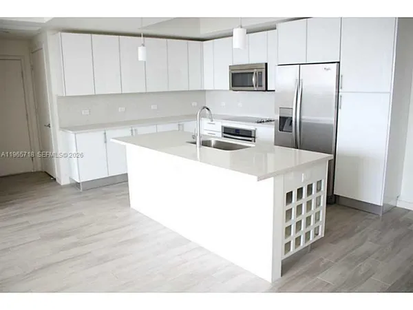 a kitchen with stainless steel appliances a microwave sink and refrigerator