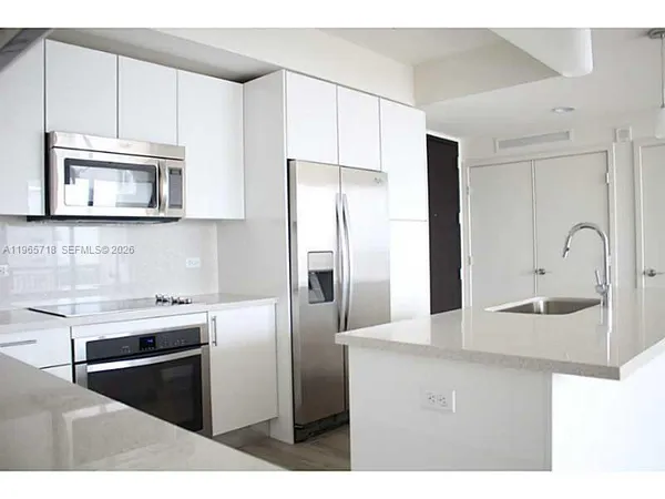 a kitchen with stainless steel appliances granite countertop a refrigerator and a sink