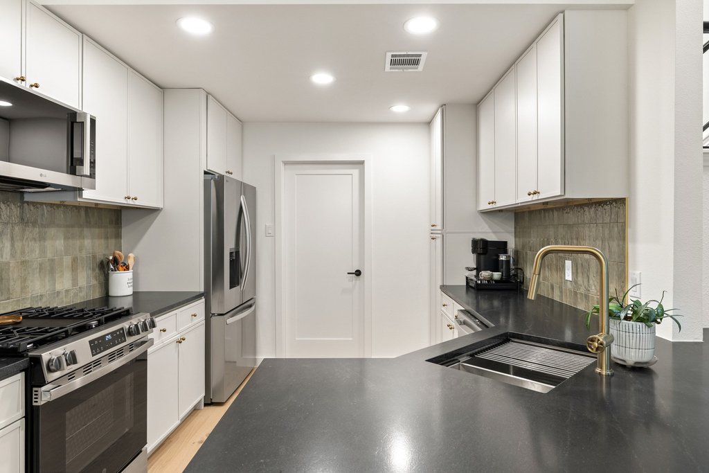 8202 Cache Drive Austin, TX 78749 - Photo 13 of 39 a kitchen with granite countertop a stove refrigerator and microwave