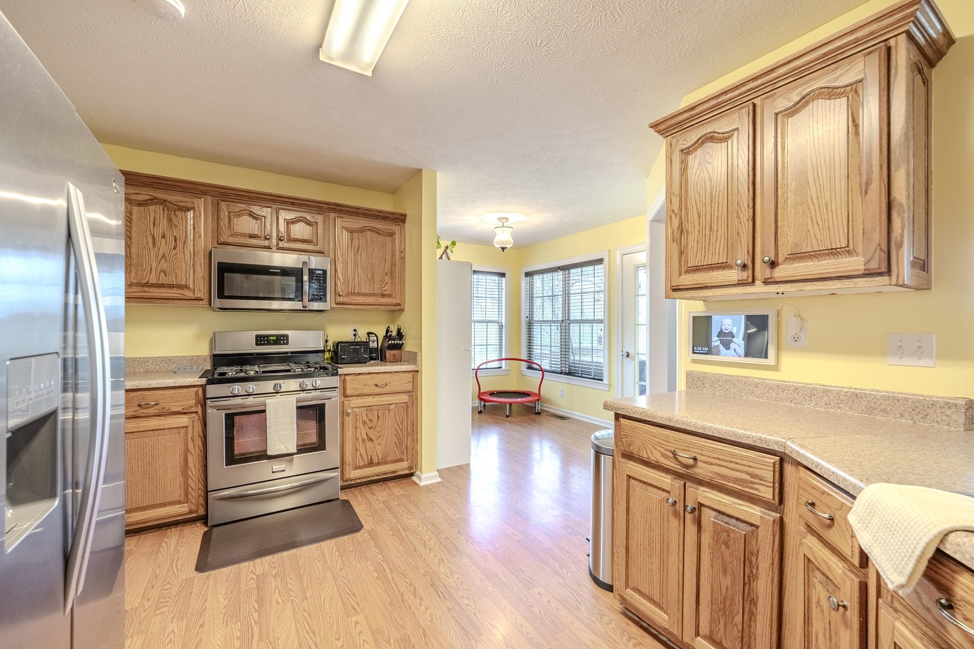 270 2 Boys Road Savannah, TN 38372 - Photo 14 of 35 Kitchen featuring stainless steel appliances, light countertops, light wood-style flooring, a textured ceiling, and wood finish cabinets