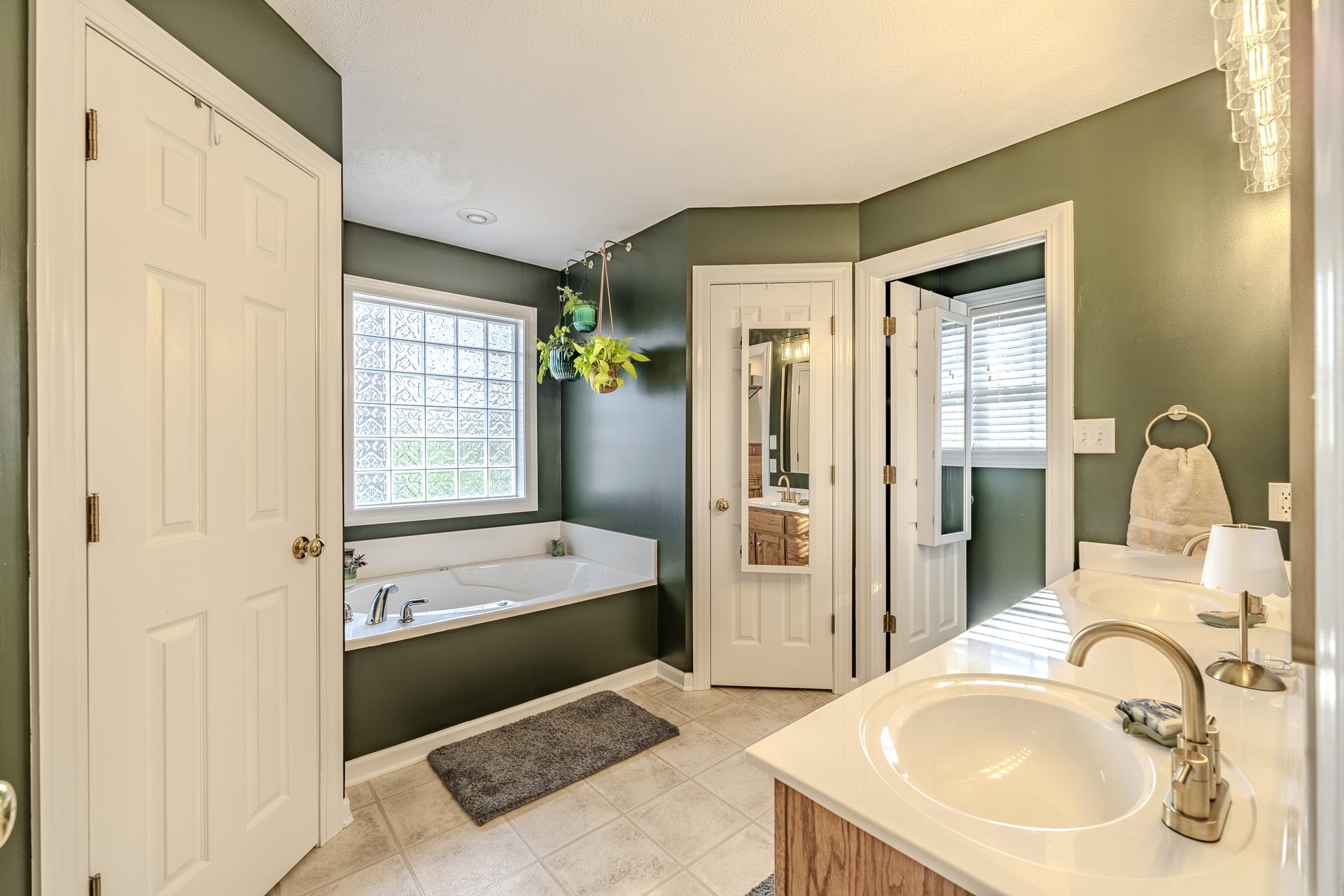 270 2 Boys Road Savannah, TN 38372 - Photo 18 of 35 Full bath featuring double vanity, healthy amount of natural light, a bath, and light tile patterned floors