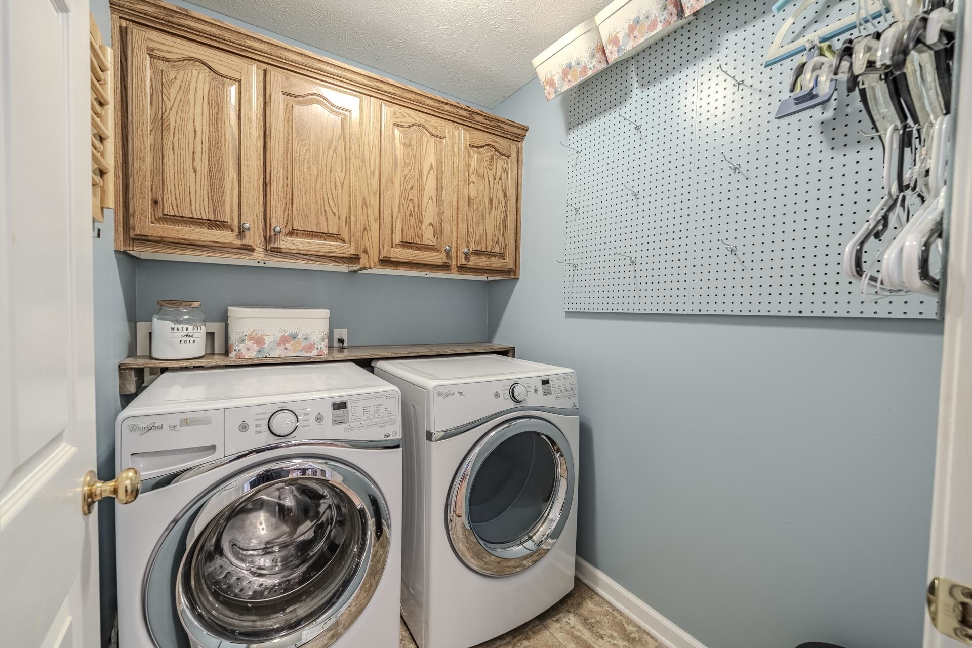 270 2 Boys Road Savannah, TN 38372 - Photo 20 of 35 Laundry area featuring cabinet space, washing machine and clothes dryer, and a textured ceiling