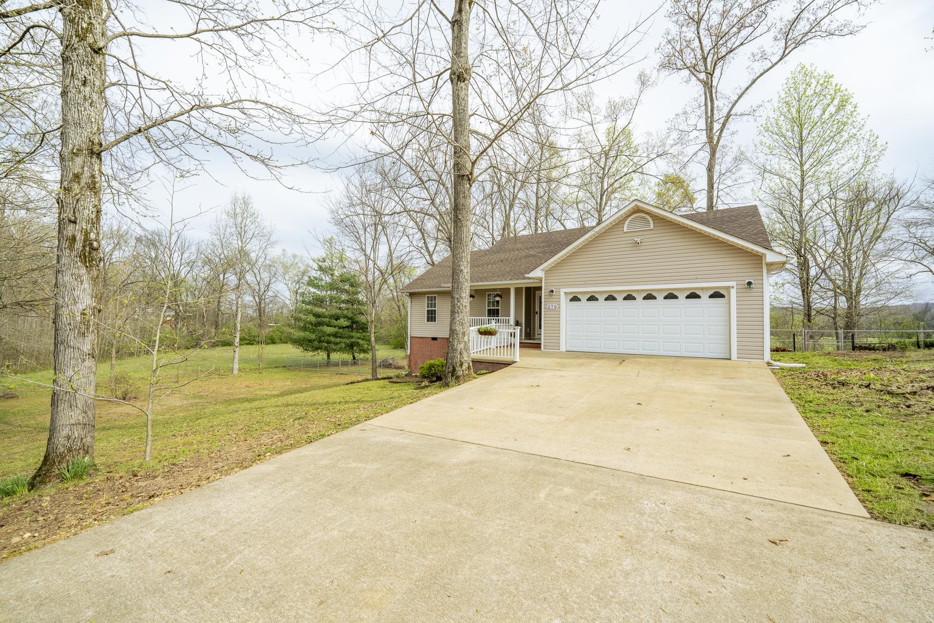 270 2 Boys Road Savannah, TN 38372 - Photo 2 of 35 View of front of house featuring concrete driveway, an attached garage, and roof with shingles