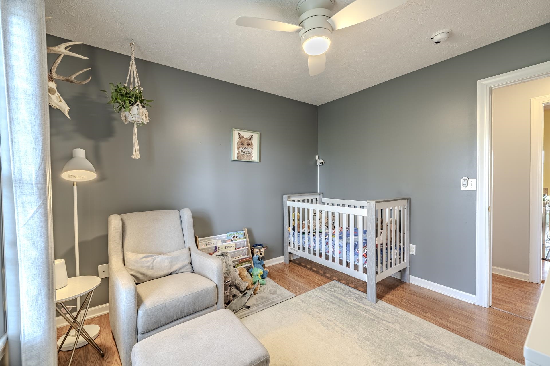 270 2 Boys Road Savannah, TN 38372 - Photo 23 of 35 Bedroom featuring a nursery area, a ceiling fan, and light wood-type flooring