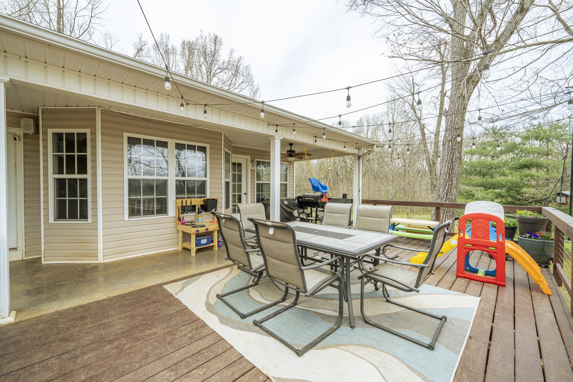 270 2 Boys Road Savannah, TN 38372 - Photo 28 of 35 Wooden deck with a ceiling fan, outdoor dining area, and a patio