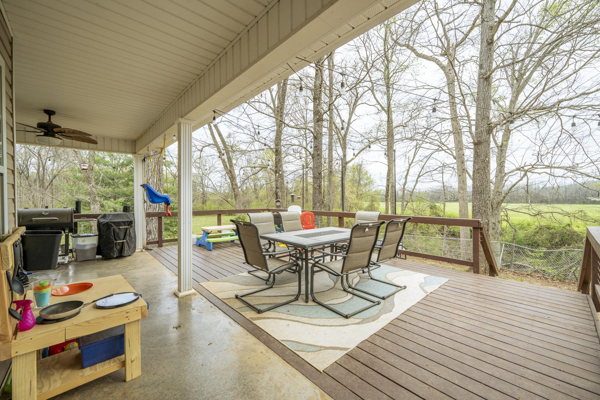 270 2 Boys Road Savannah, TN 38372 - Photo 29 of 35 Wooden terrace featuring outdoor dining space, ceiling fan, and area for grilling