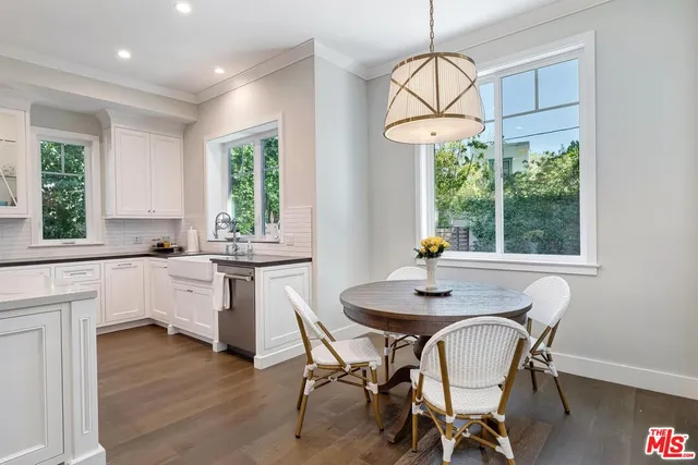 a view of a patio with table and chairs potted plants with floor to ceiling window and potted plants
