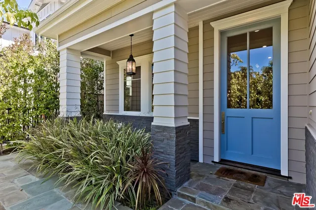 a view of a door of the house with a tree