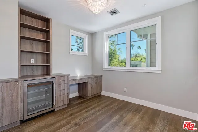a view of a kitchen with a refrigerator and wooden floor