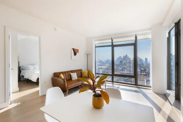 a large white kitchen with stainless steel appliances granite countertop a lot of counter space and a window