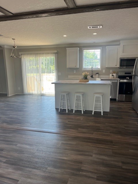 44060 Bryce Lane Callahan, FL 32011 - Photo 3 of 12 a large white kitchen with kitchen island granite countertop a stove top oven a sink and white cabinets with wooden floor