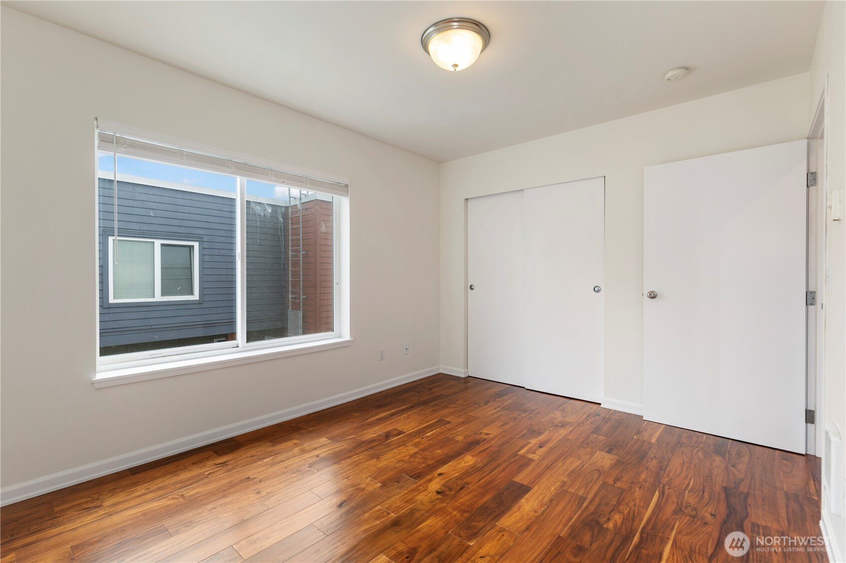 2440 Western Avenue, Unit 807 Seattle, WA 98121 - Photo 19 of 32 an empty room with wooden floor and windows