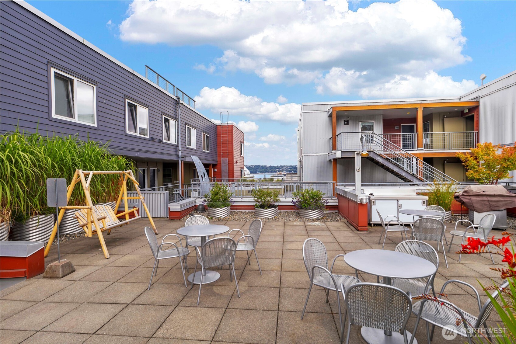 2440 Western Avenue, Unit 807 Seattle, WA 98121 - Photo 25 of 32 a view of a patio with a dining table and chairs with wooden fence