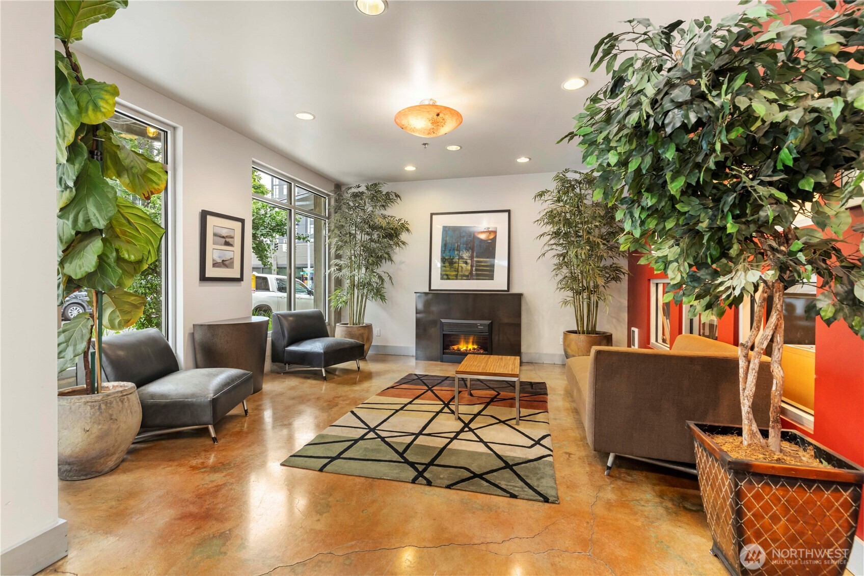 2440 Western Avenue, Unit 807 Seattle, WA 98121 - Photo 28 of 32 a living room with furniture a fireplace and a potted plant