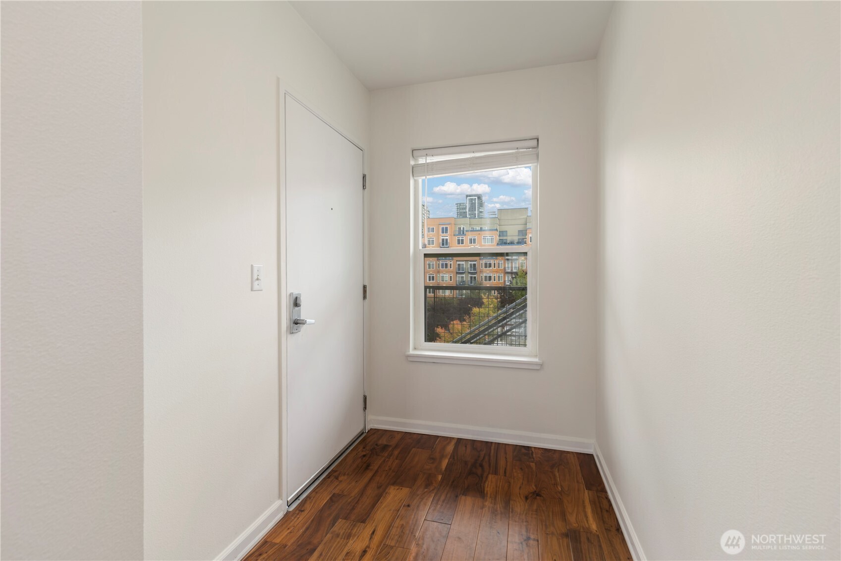 2440 Western Avenue, Unit 807 Seattle, WA 98121 - Photo 5 of 32 a view of an empty room with wooden floor and a window