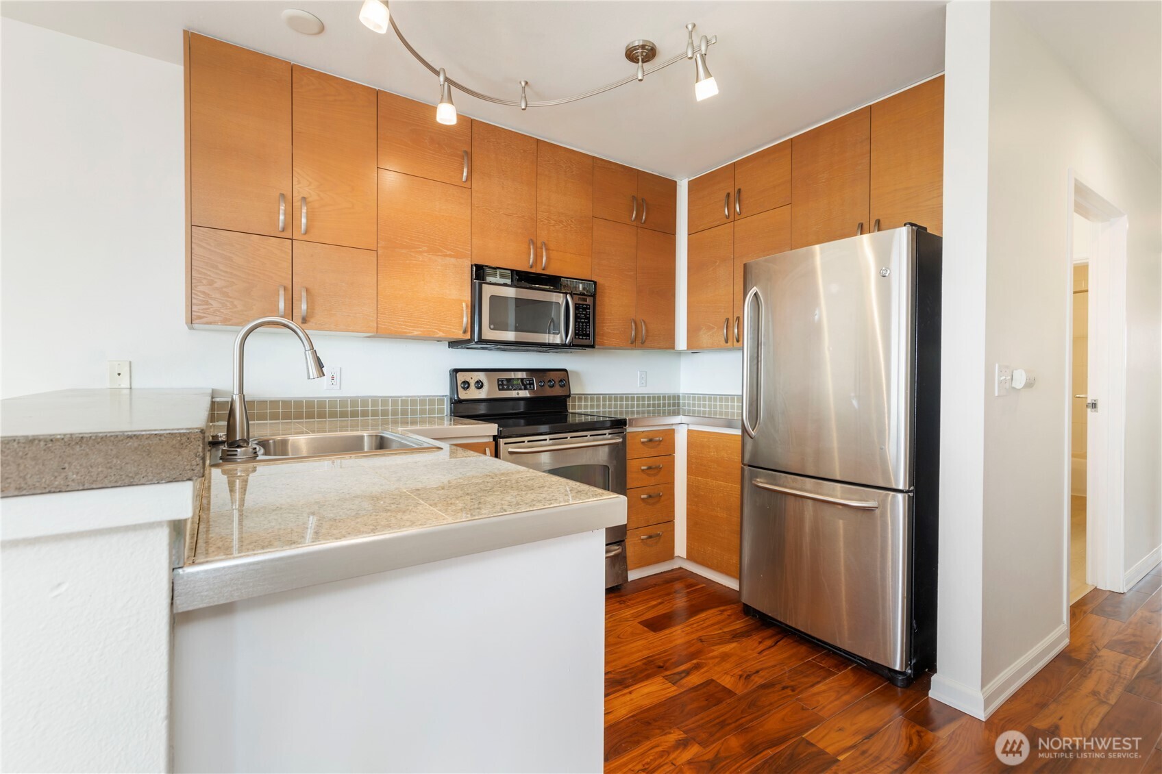 2440 Western Avenue, Unit 807 Seattle, WA 98121 - Photo 7 of 32 a kitchen with kitchen island a counter top space cabinets and stainless steel appliances