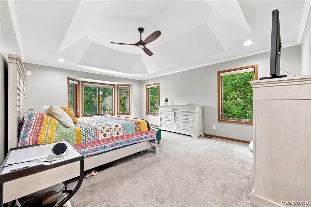 8610 Ferry Road Grosse Ile, MI 48138 - Photo 29 of 55 Tray ceiling with recessed lighting and a ceiling fan, bay window with wood-frame windows, additional wood-frame windows, and plush carpet flooring