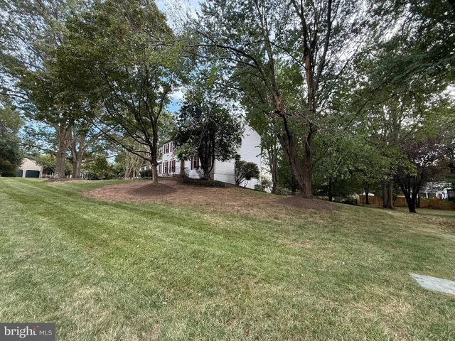 a view of a white house with a yard and plants
