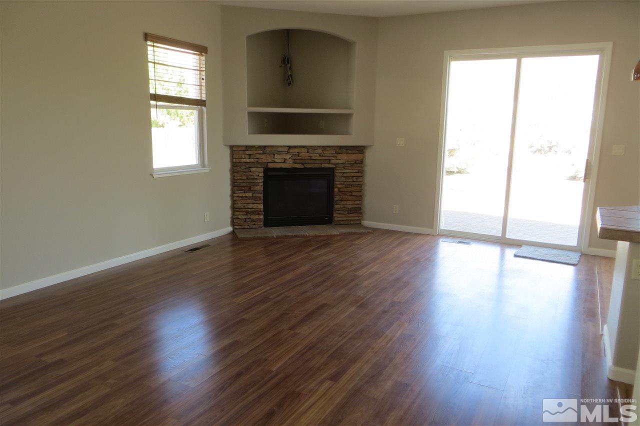 10092 Cascade Falls Drive Reno, NV 89521 - Photo 5 of 22 an empty room with wooden floor fireplace and windows