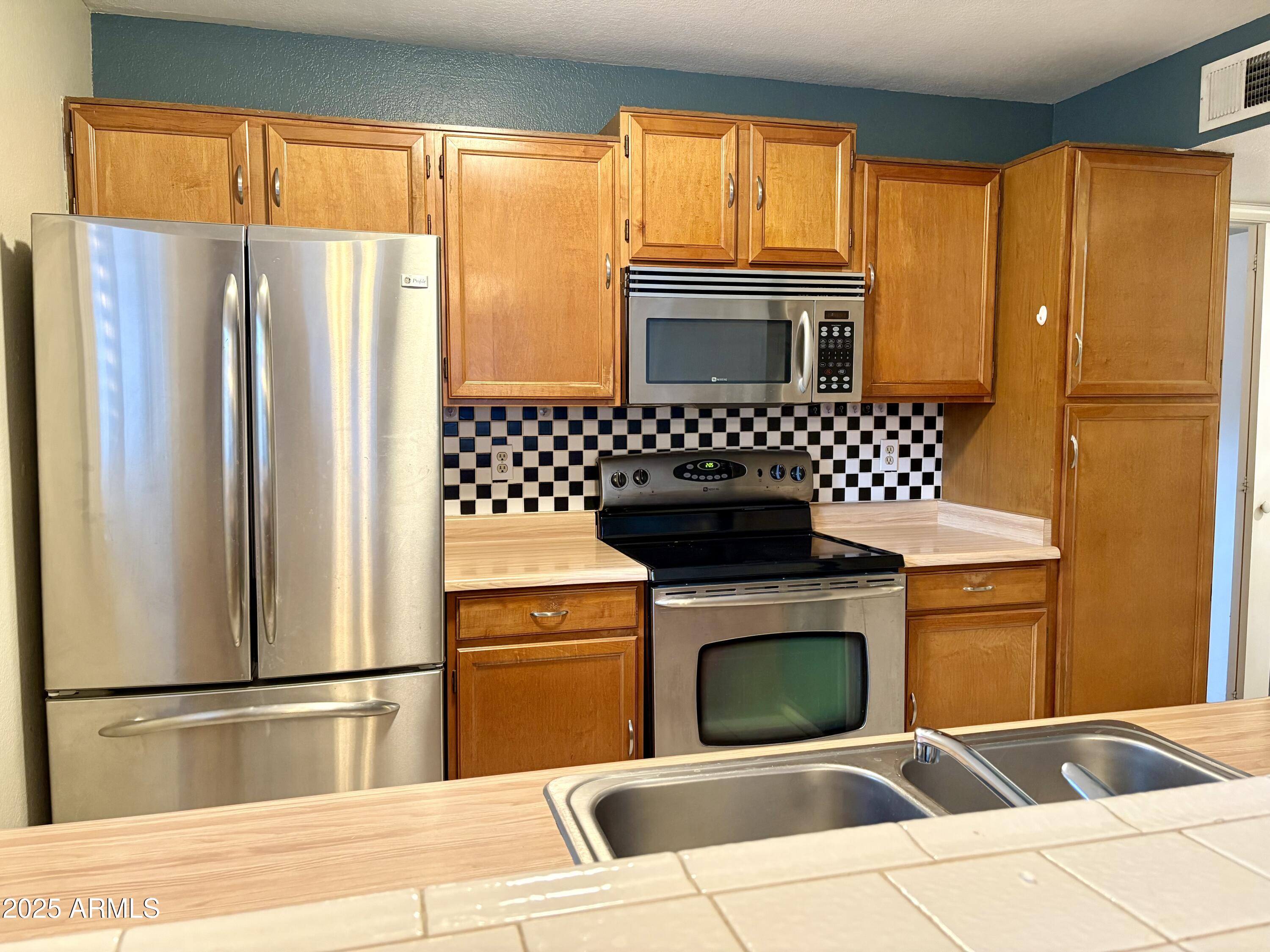 533 West Guadalupe Road, Unit 1122 Mesa, AZ 85210 - Photo 3 of 24 a kitchen with a refrigerator and a stove