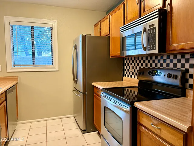a kitchen with stainless steel appliances granite countertop a refrigerator and a stove
