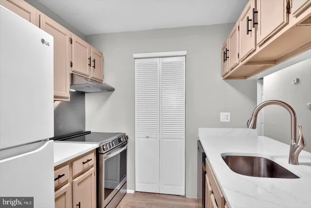 a kitchen with stainless steel appliances a sink a stove and a refrigerator