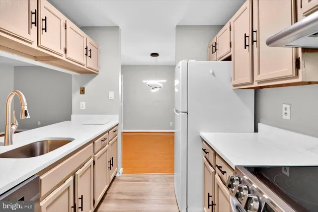 a kitchen with stainless steel appliances a sink and a refrigerator