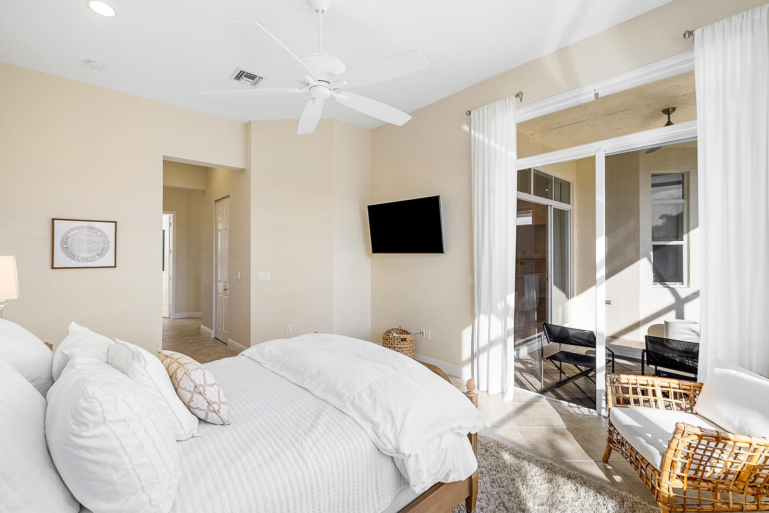 9666 Via Elegante Wellington, FL 33411 - Photo 18 of 37 a bedroom with a bed and a flat tv screen on wall